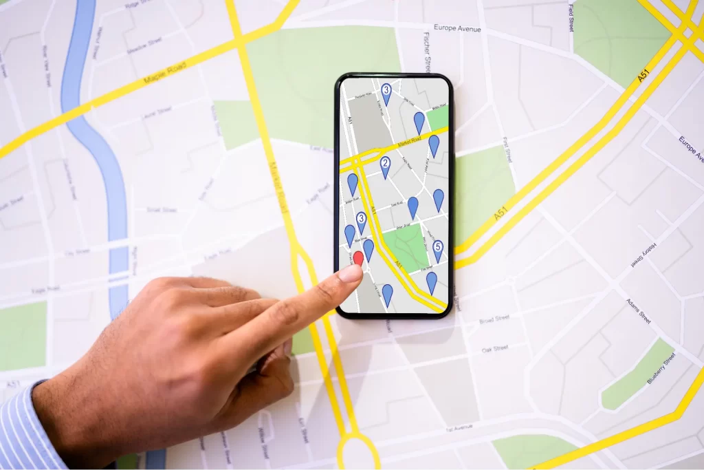 Hand pointing to a phone screen showing a map